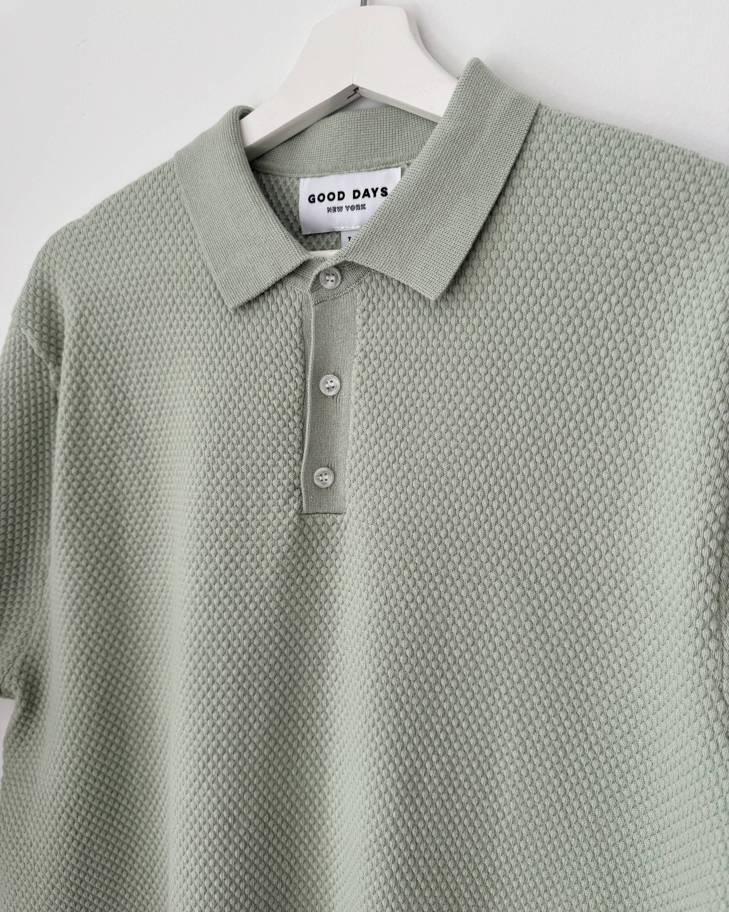 Green textured polo shirt on a hanger with 'Good Days' label.