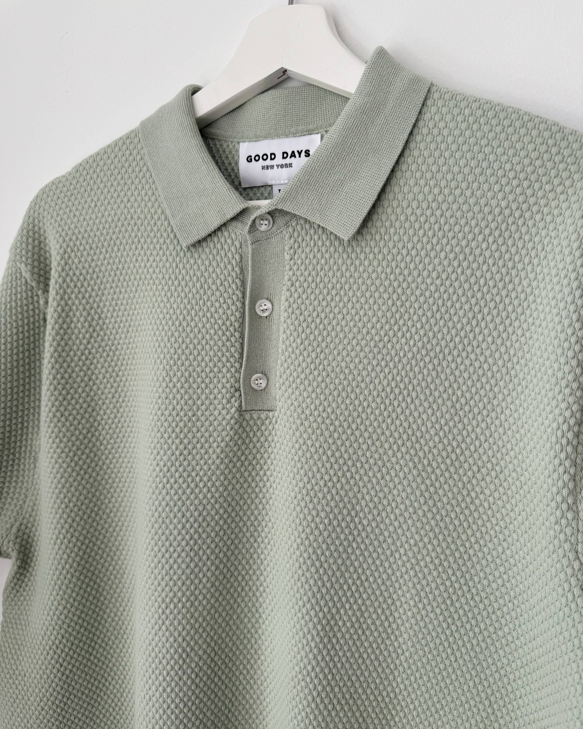 Green textured polo shirt on a hanger with 'Good Days' label.
