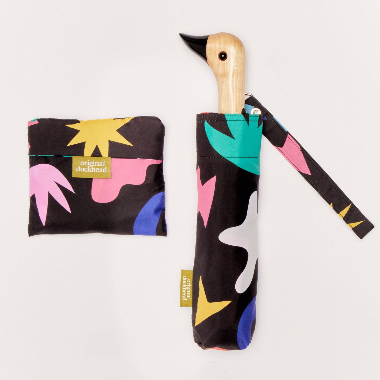 Colorful umbrella with a wooden handle and matching pouch on a light gray background
