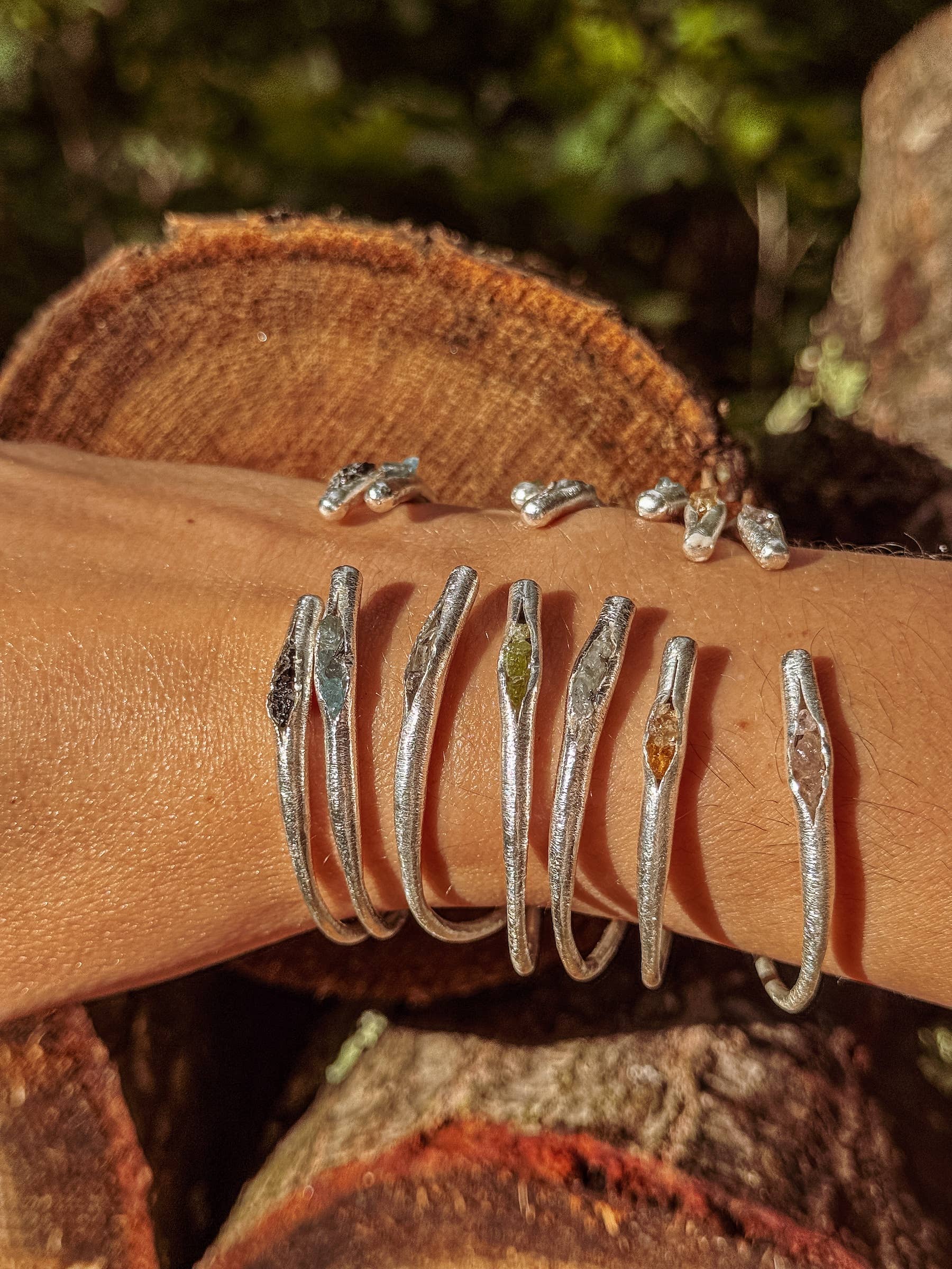 Silver rings on a person's wrist with a natural background