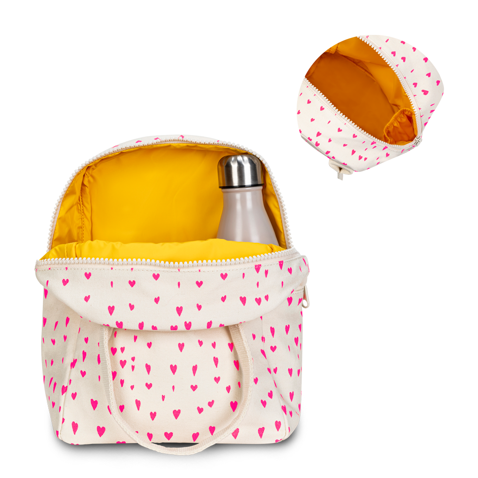 An off-white insulated lunch bag with a pink heart pattern, shown open with a silver bottle inside. A smaller inset image in the top right shows the bag's yellow interior and zipper closure from a different angle, all on a solid white background.