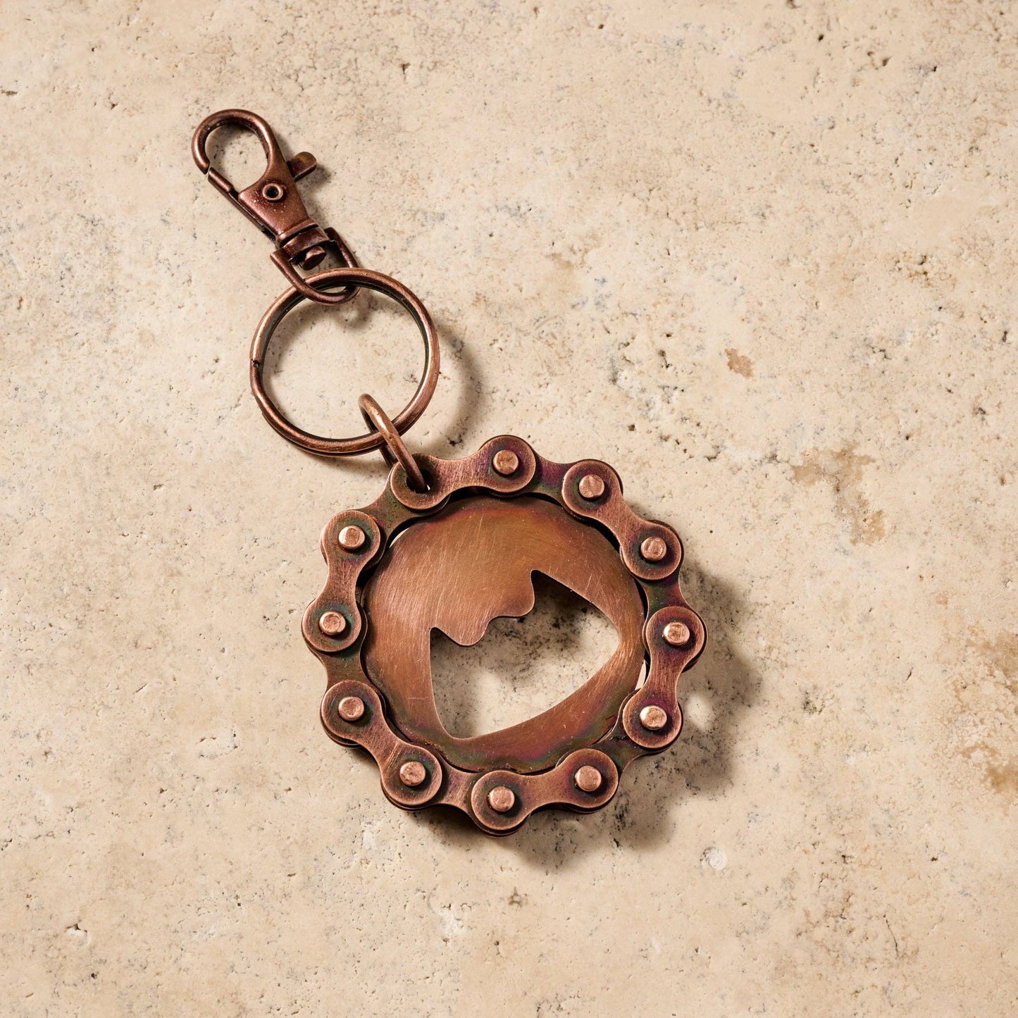 Copper keychain with a unique design on a beige background