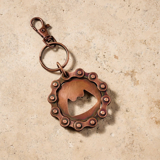 Copper keychain with a unique design on a beige background