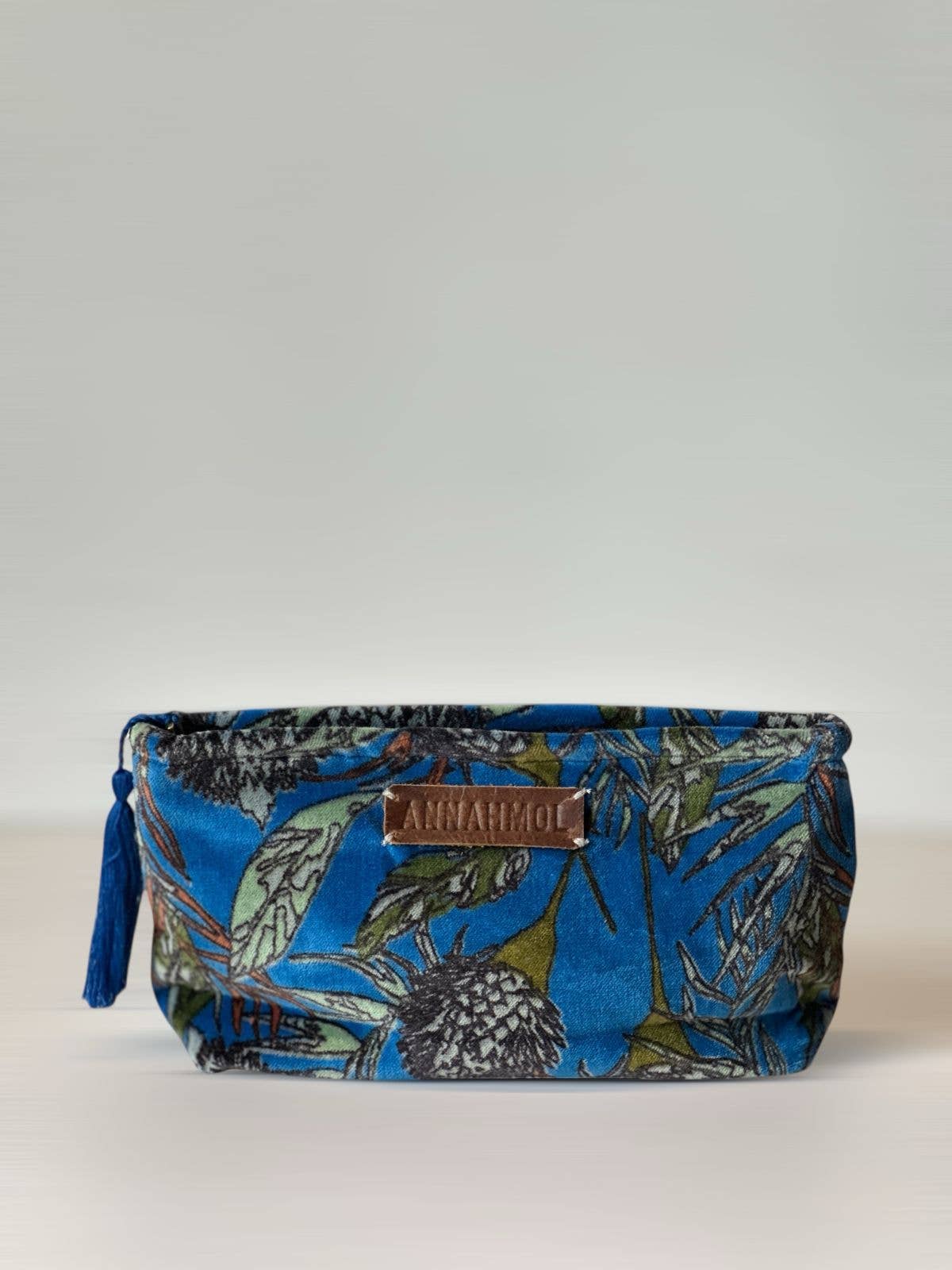Floral-patterned pouch with a brand label on a white background