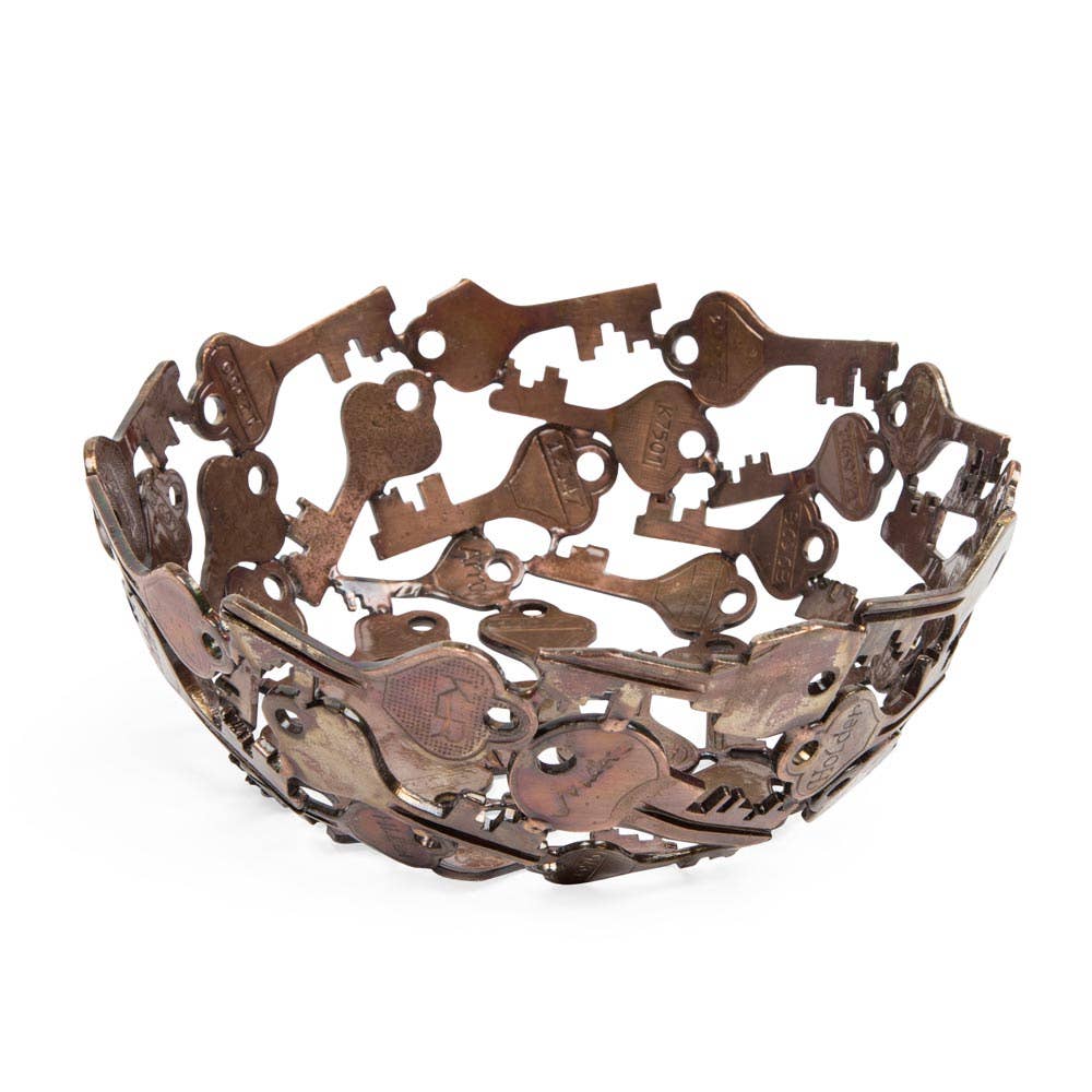 Decorative metal bowl with key design on a white background