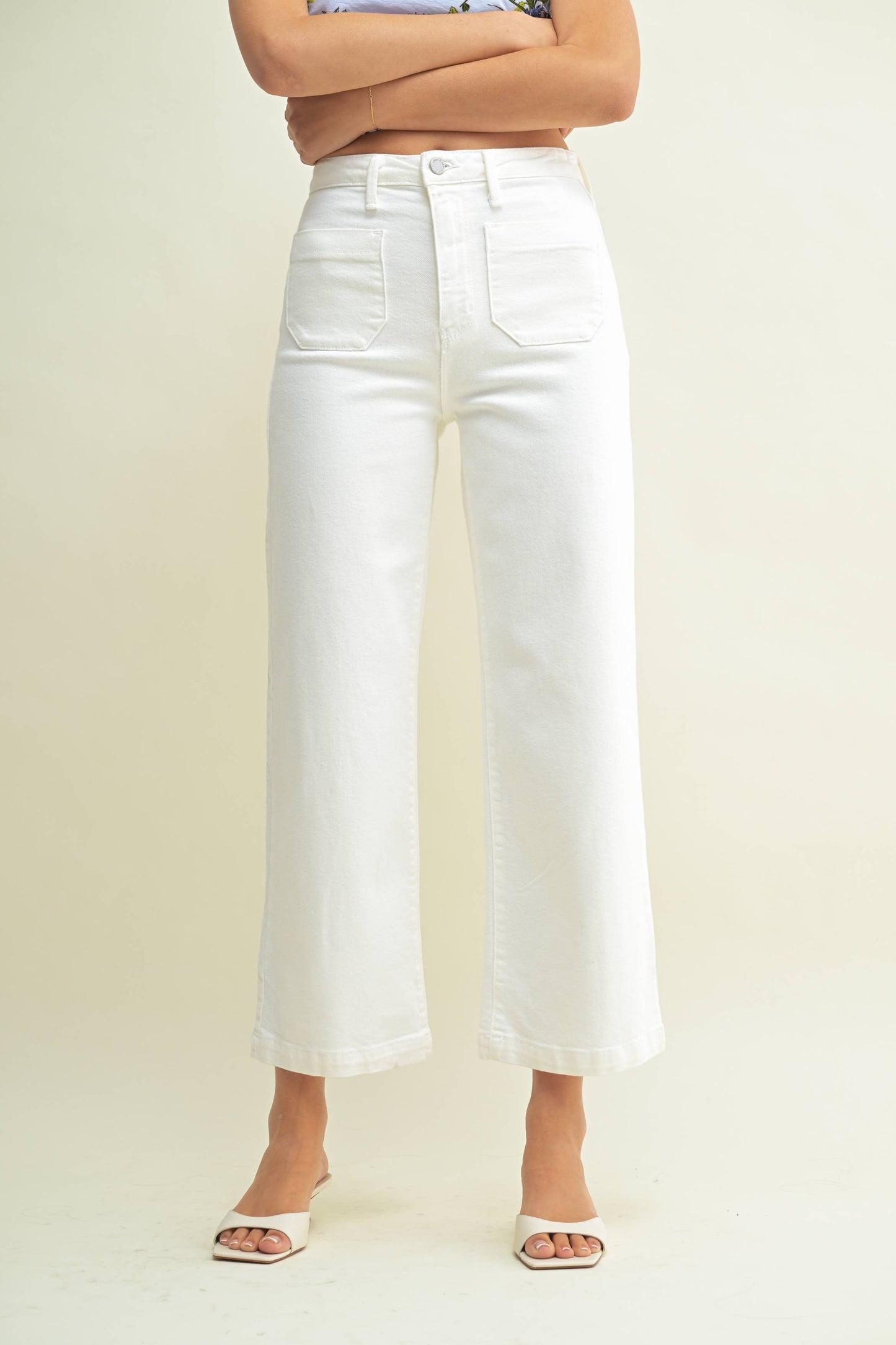 Person wearing white wide-leg jeans on a plain background