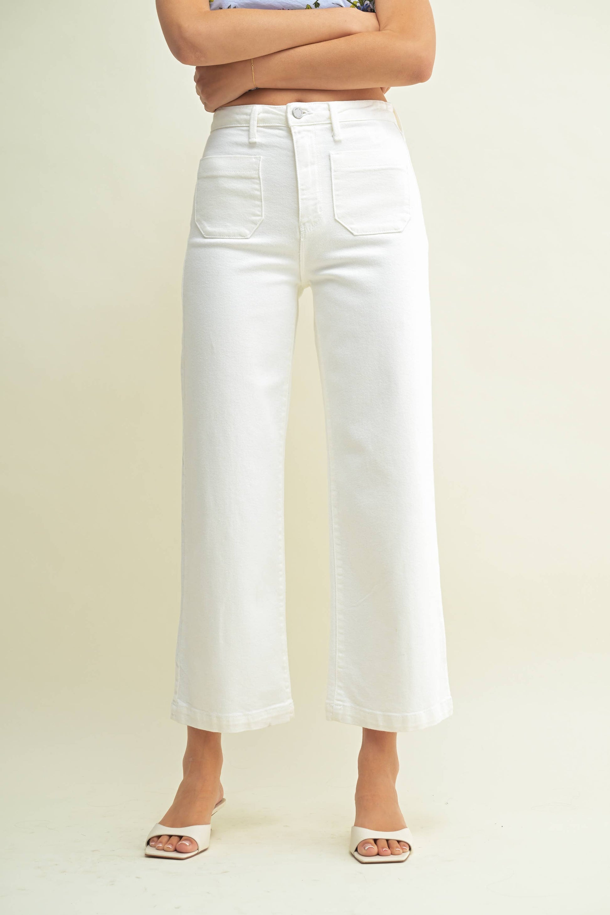 Person wearing white wide-leg jeans on a plain background