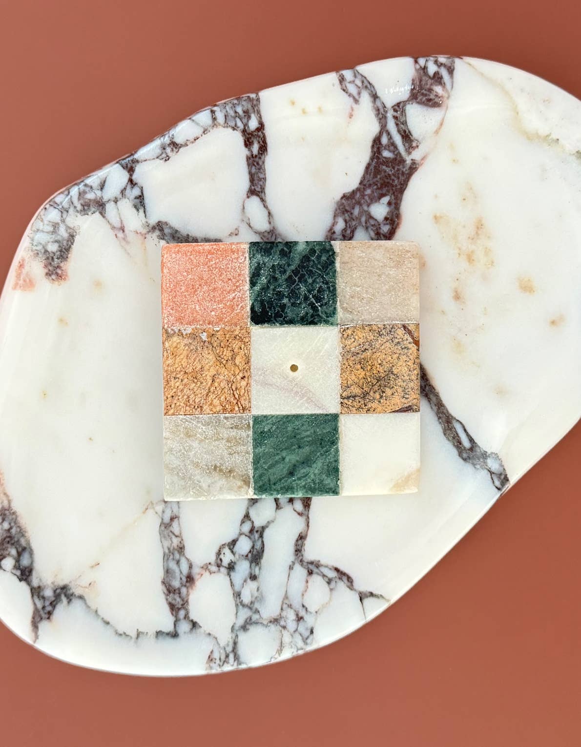 Marble-patterned soap with a square section displaying a grid of colors on a brown background