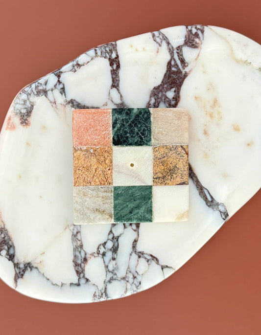 Marble-patterned soap with a square section displaying a grid of colors on a brown background