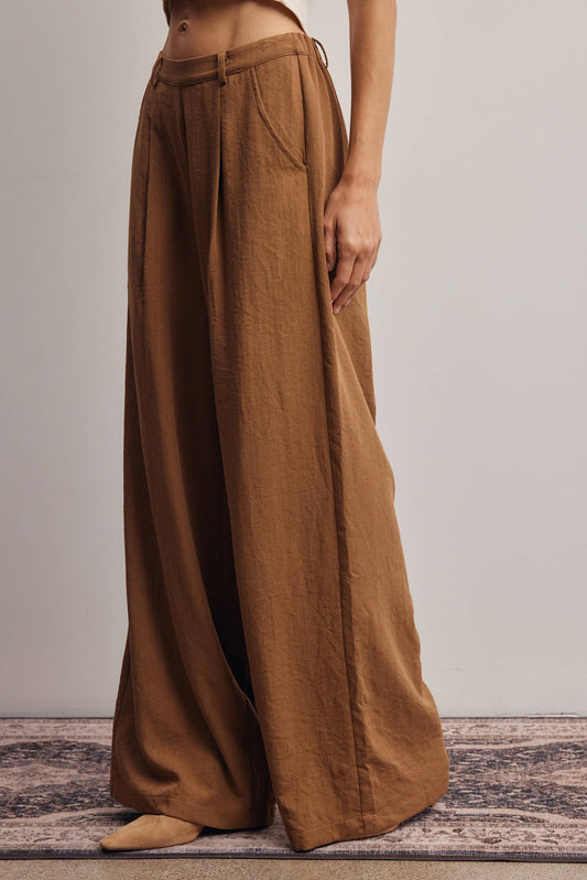 Brown wide-leg pants worn by a person on a neutral background