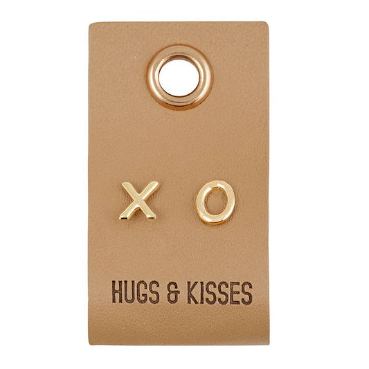 Gold 'XO' earrings on a brown card with 'Hugs & Kisses' text.