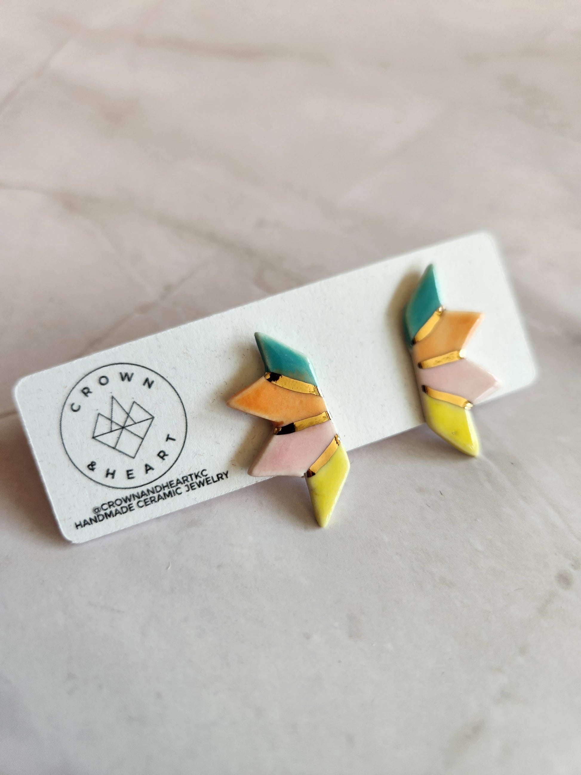 Colorful geometric earrings on a white card with 'Crown & Heart' branding.