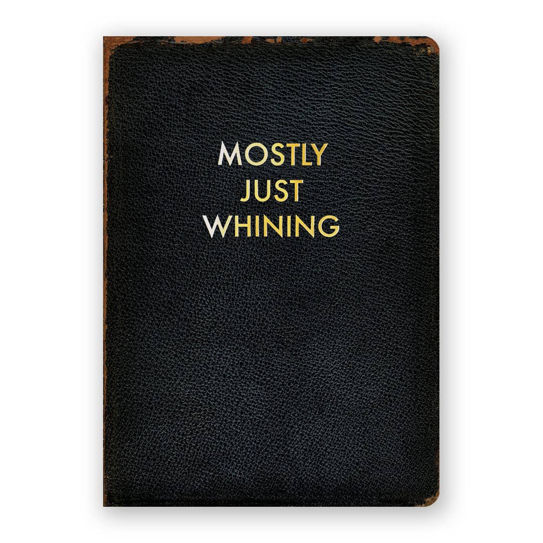 Black leather notebook with gold text 'MOSTLY JUST WHINING' on a white background