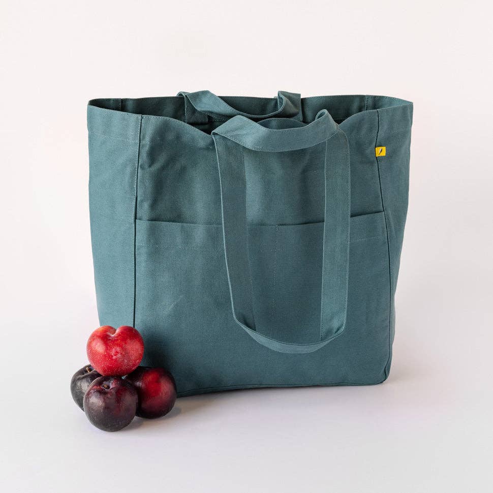 Teal tote bag with a yellow label on a white background