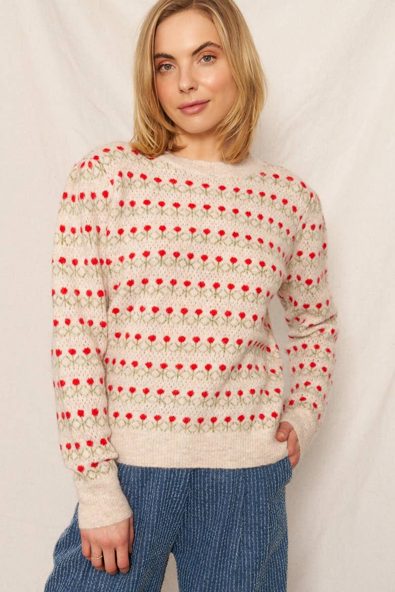 Woman wearing a sweater with a red and white pattern against a plain background