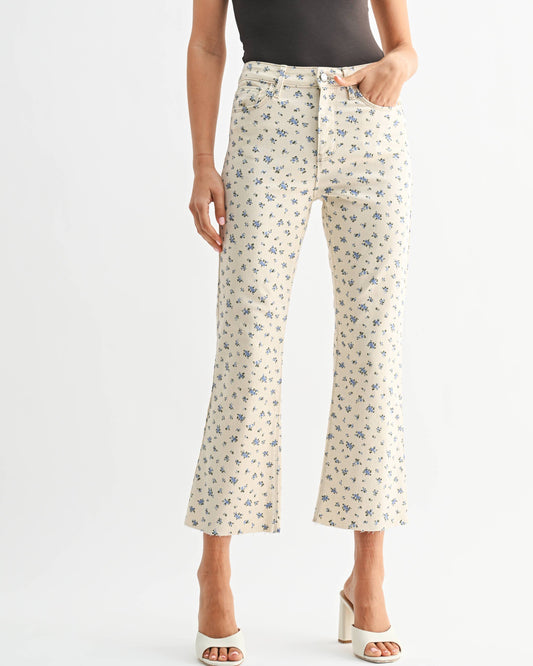 Woman wearing a black tank top and patterned pants on a white background