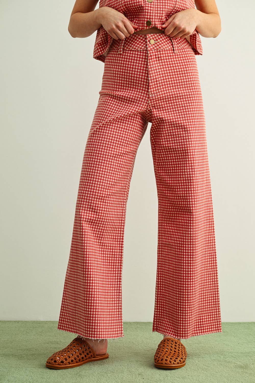 Person wearing red and white checkered pants on a plain background