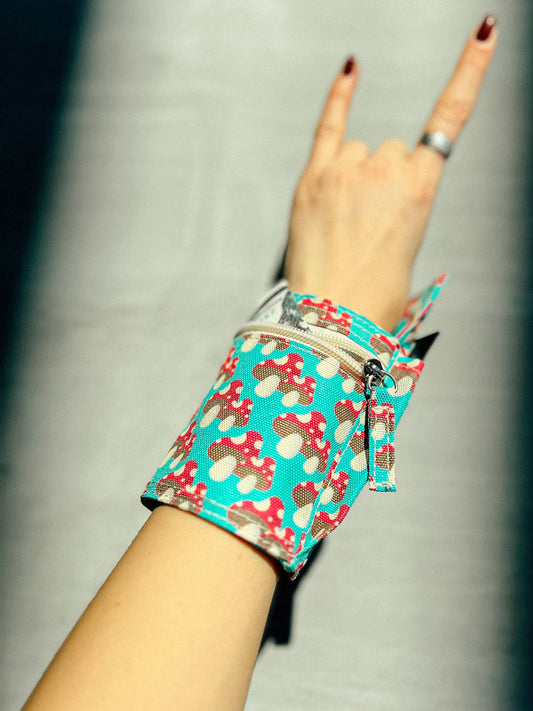 Wristlet with cartoon character pattern worn on wrist against a neutral background