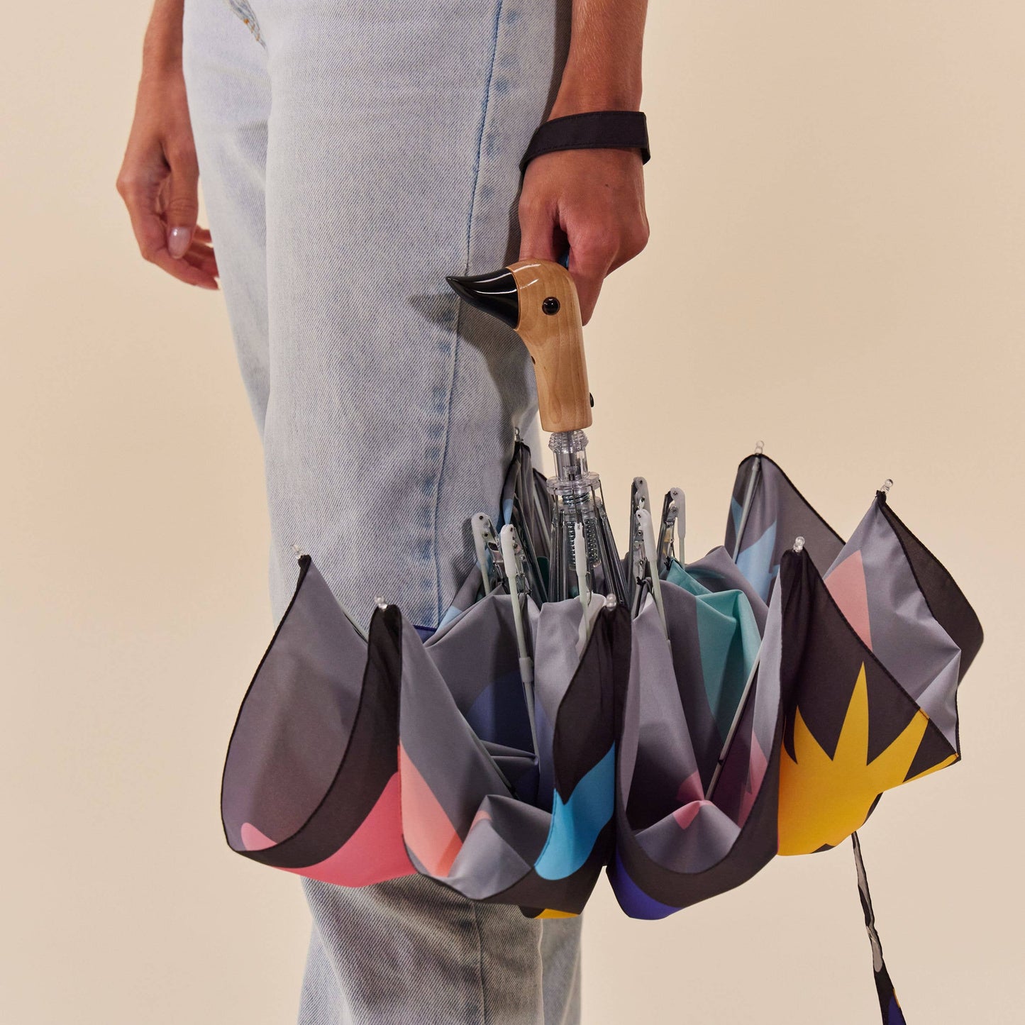 Person holding a unique umbrella with multiple colorful sections.