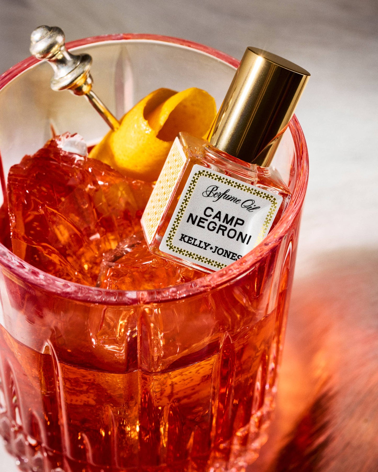 Camp Negroni cocktail with a bottle labeled 'Kelly Jones' in a red glass.