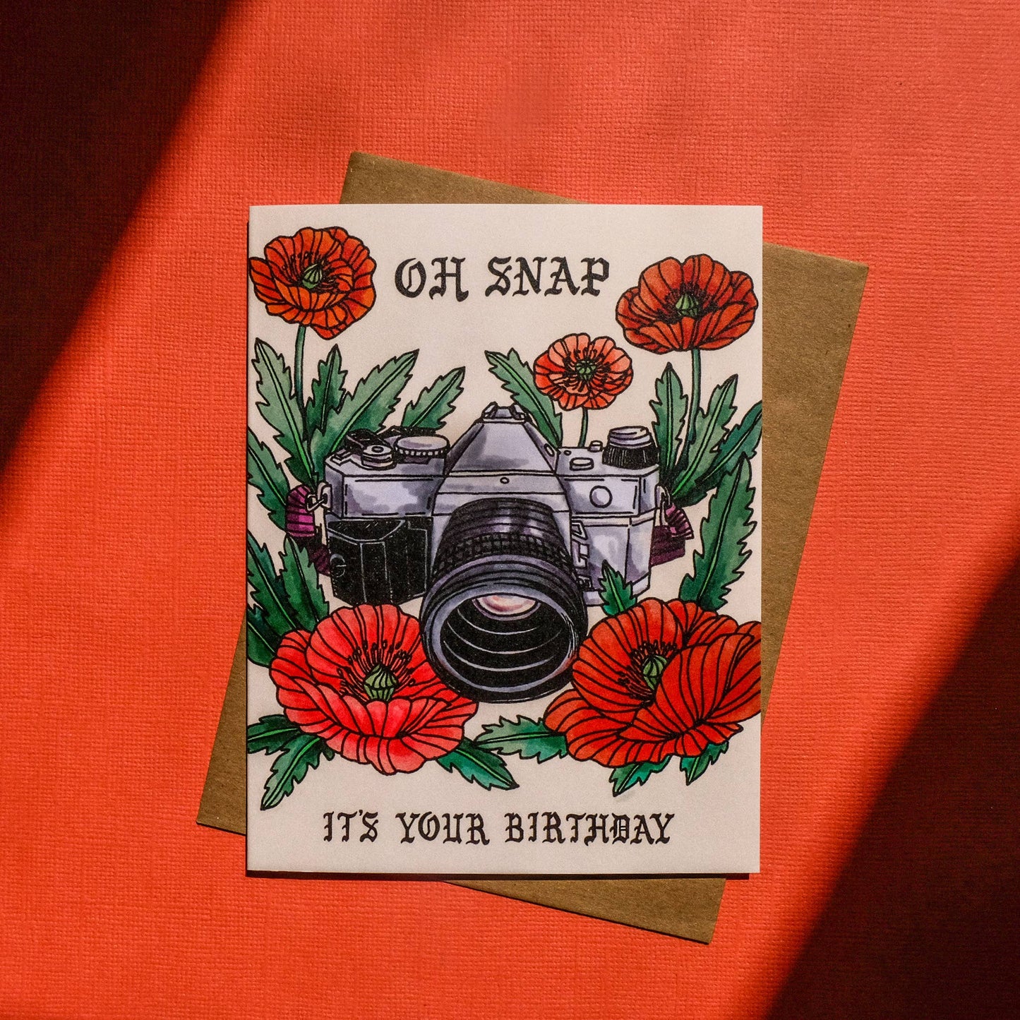 Greeting card with camera and flowers design on an orange background