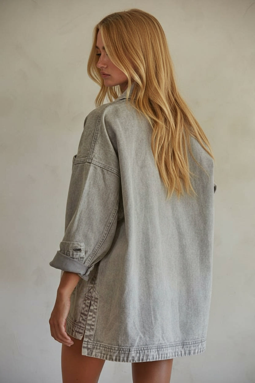 Woman wearing a light gray denim jacket against a plain background