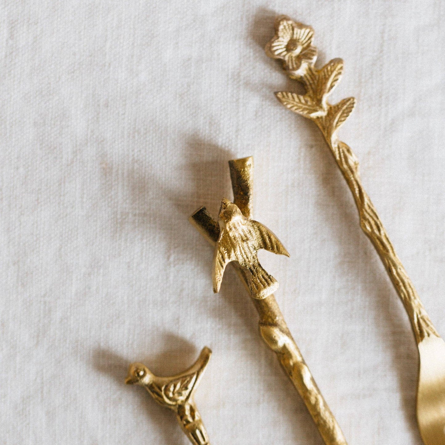 Gold bird and branch decorative items on a light background