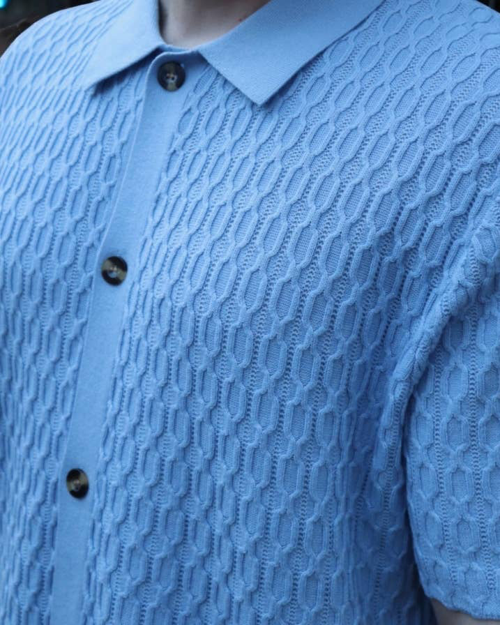 Close-up of a blue textured shirt with buttons