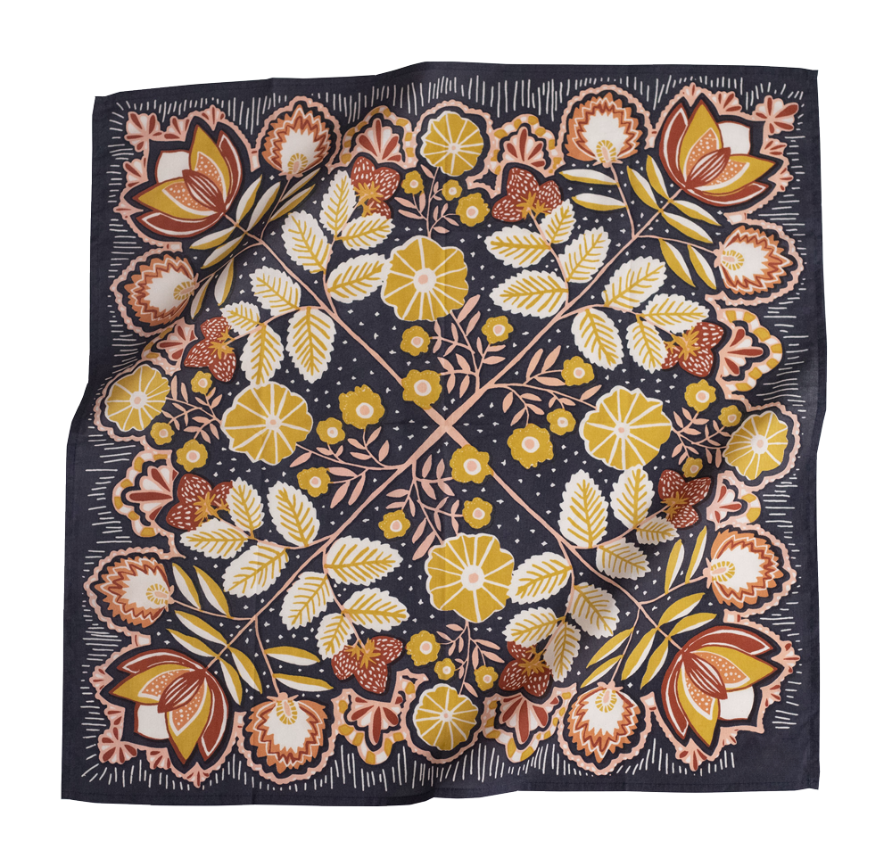 A square silk scarf with a symmetrical floral block-print pattern in yellow, brown, and white on a dark navy blue background, shown floating with soft folds.