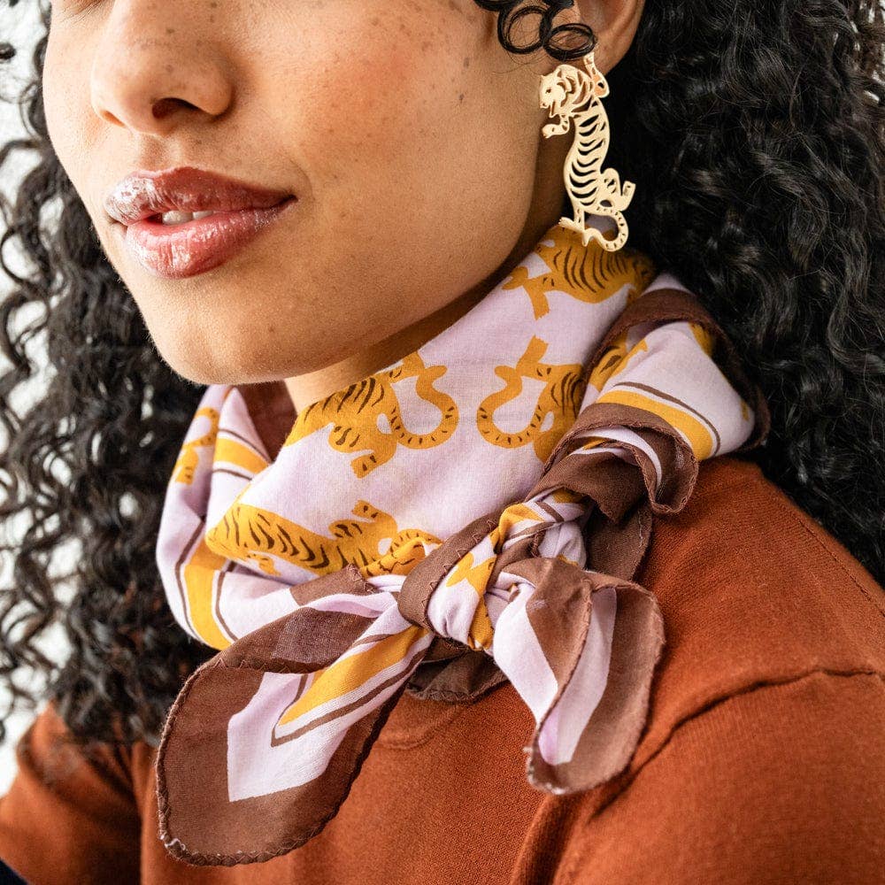 Close-up of a person wearing a patterned scarf and gold earrings.