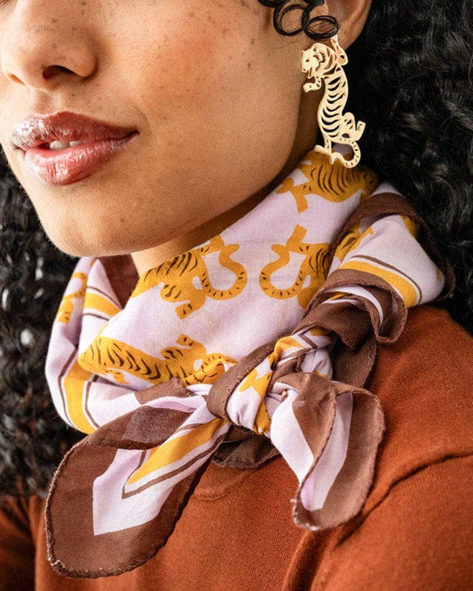 Close-up of a person wearing a patterned scarf and gold earrings.