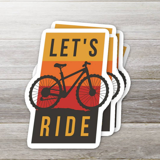 Stack of 'Let's Ride' bicycle-themed stickers on a wooden surface