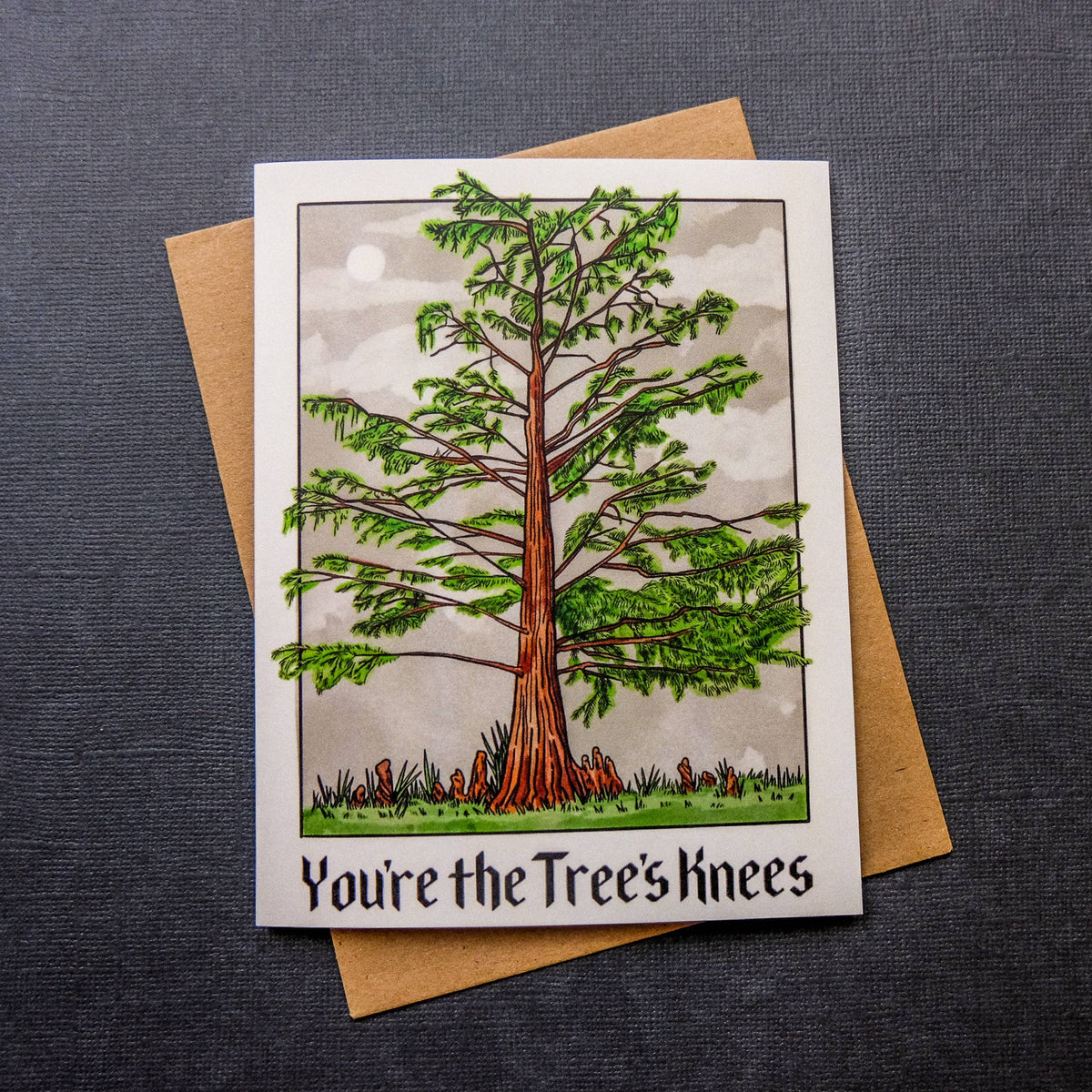 Greeting card with a tree illustration and 'You're the Tree's Knees' text on a gray background.