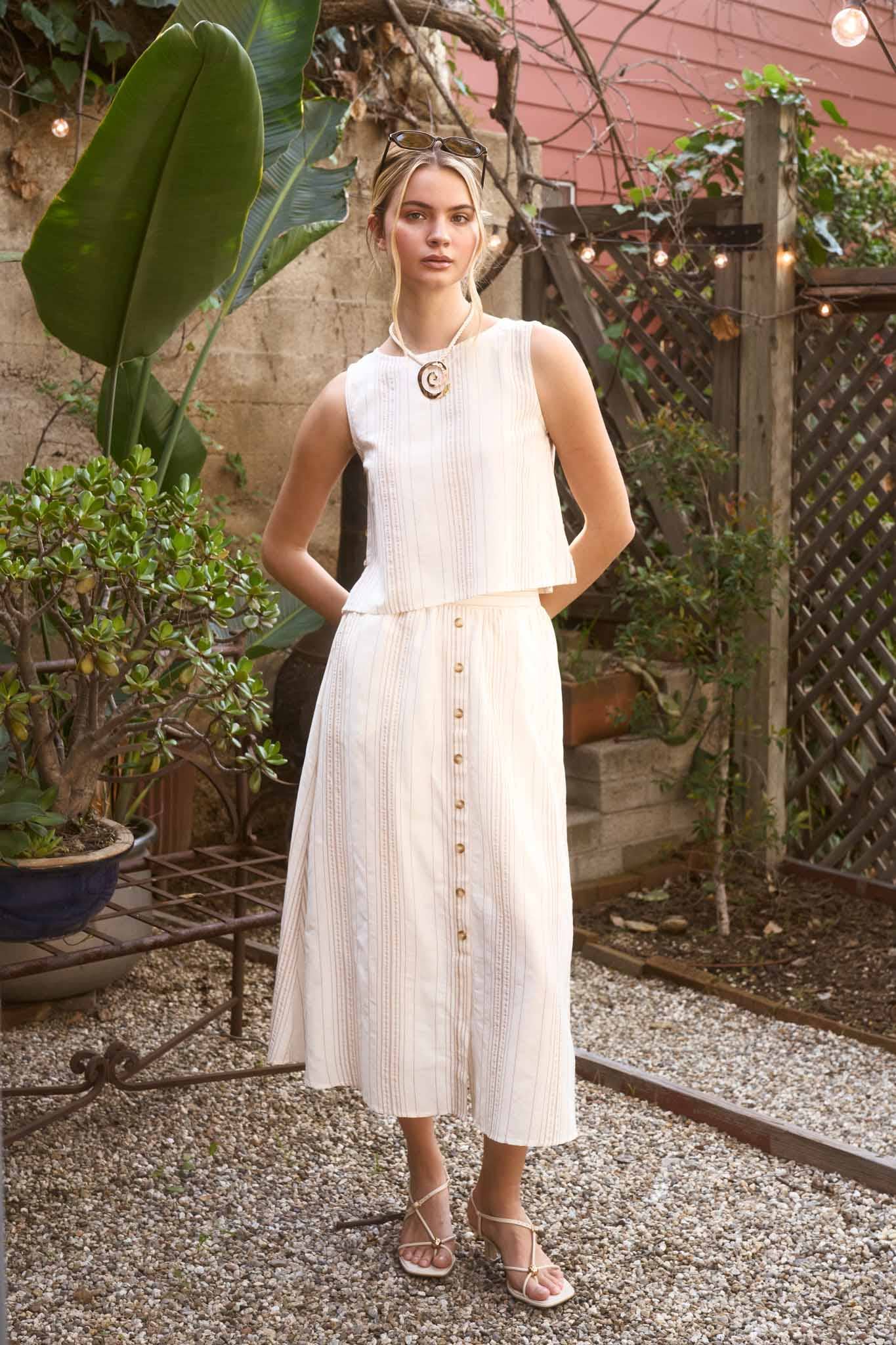 Woman in a white dress standing in an outdoor garden setting