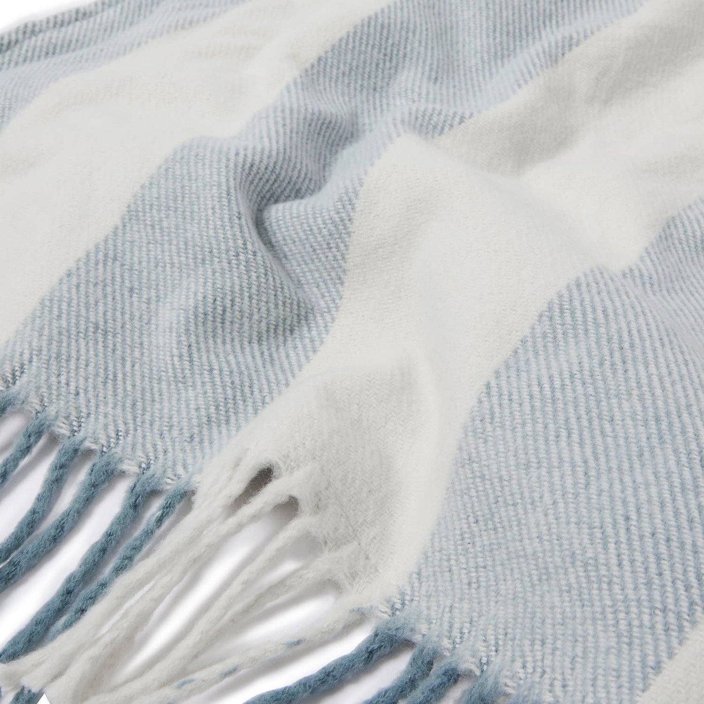 Close-up of a blue and white plaid blanket with fringes.