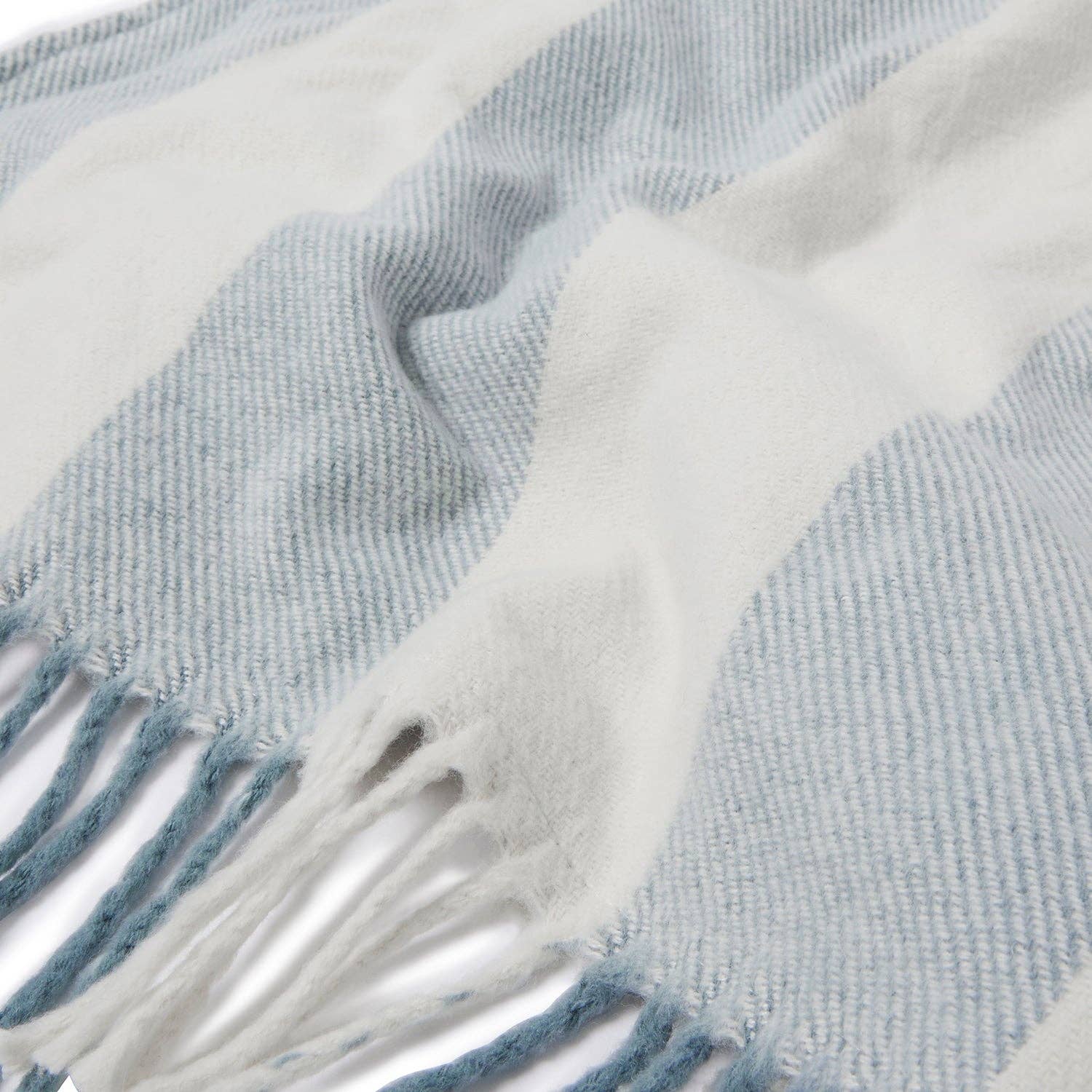 Close-up of a blue and white plaid blanket with fringes.