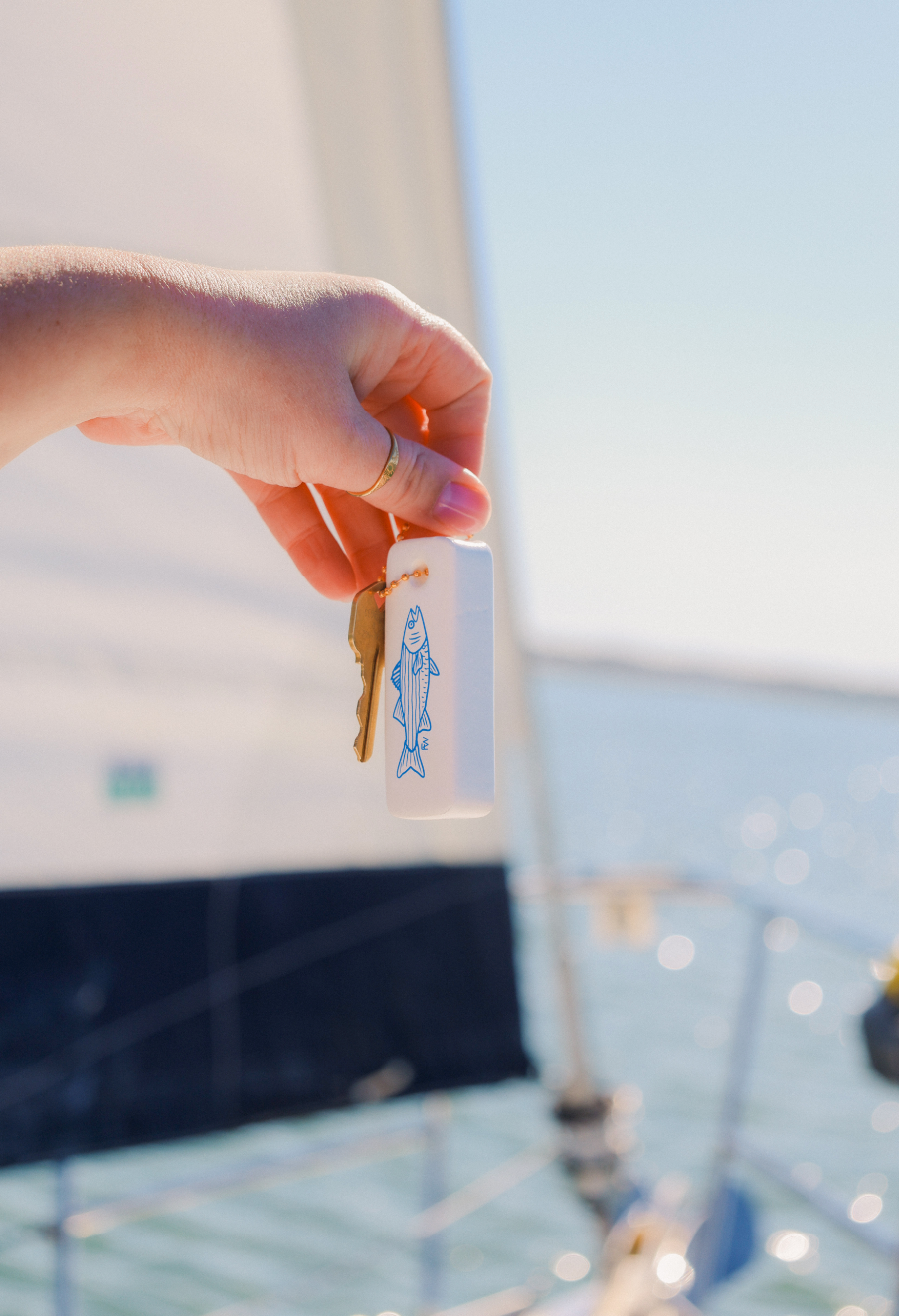 Hand holding a bottle with a key against a blurred background