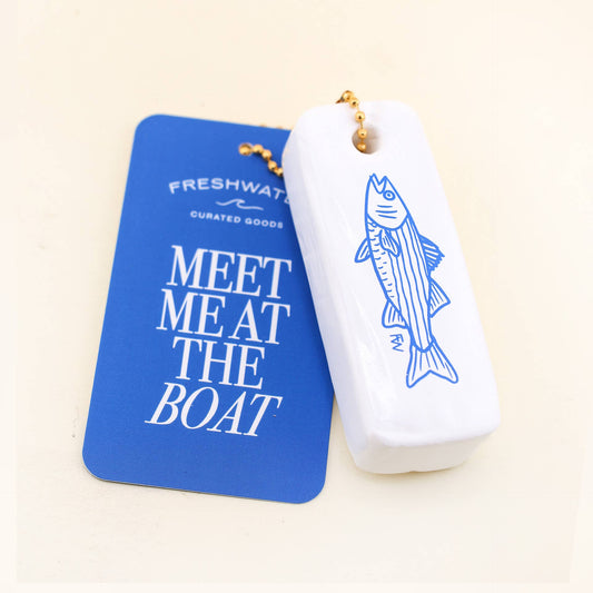 White container with fish design and blue card with text on a beige background