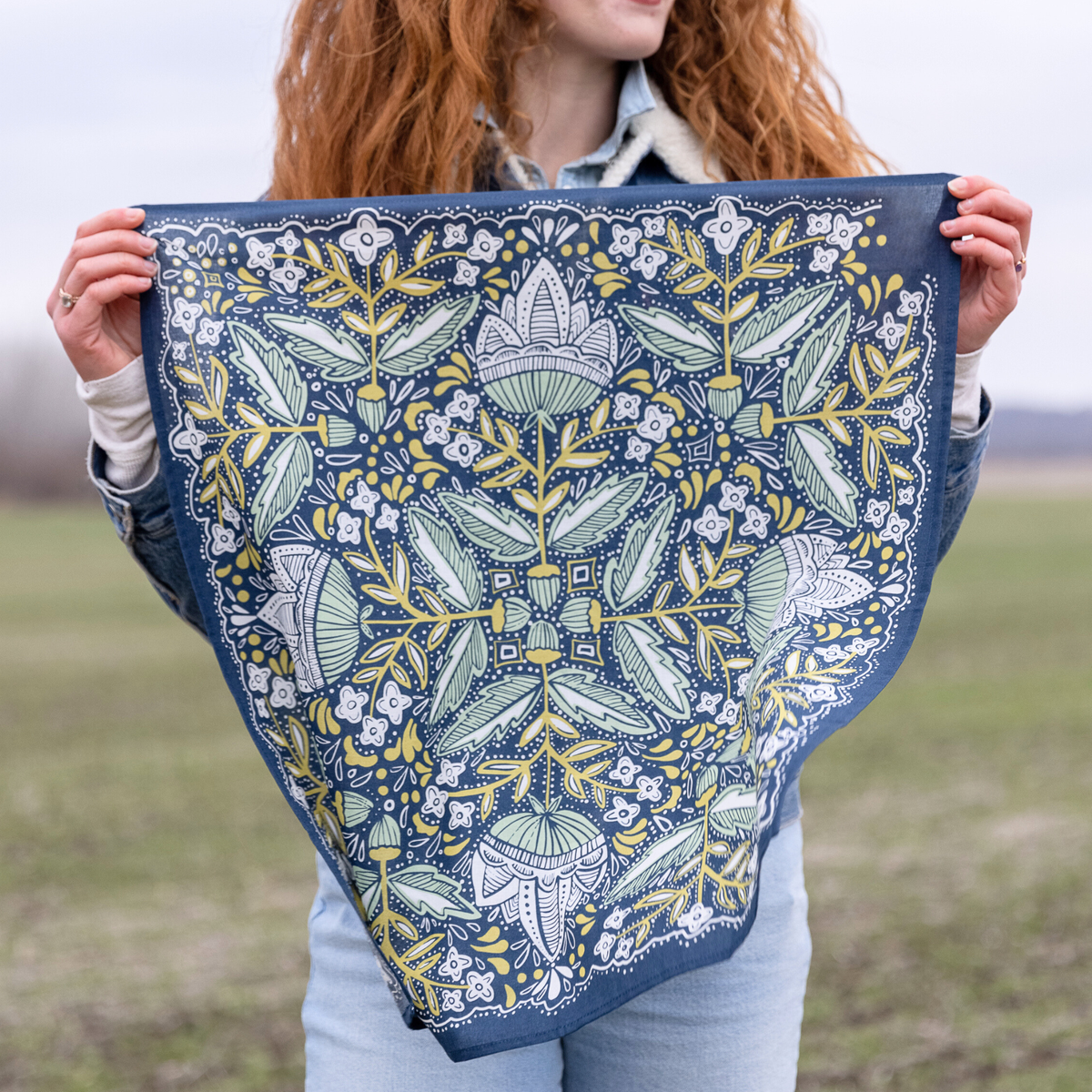 Person holding a floral patterned fabric in an outdoor setting