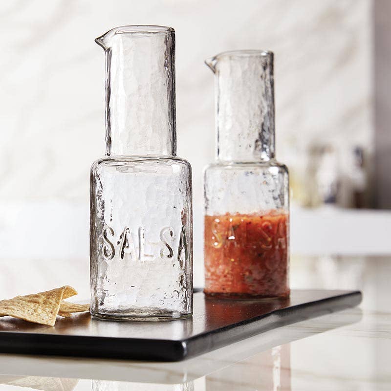 Two glass jars labeled 'Sals' on a marble surface with a blurred kitchen background.