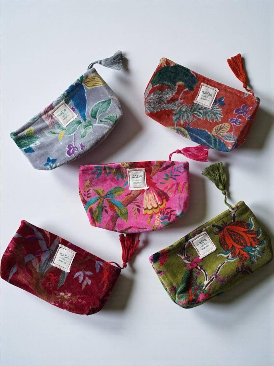 Five colorful fabric pouches with floral patterns on a white background