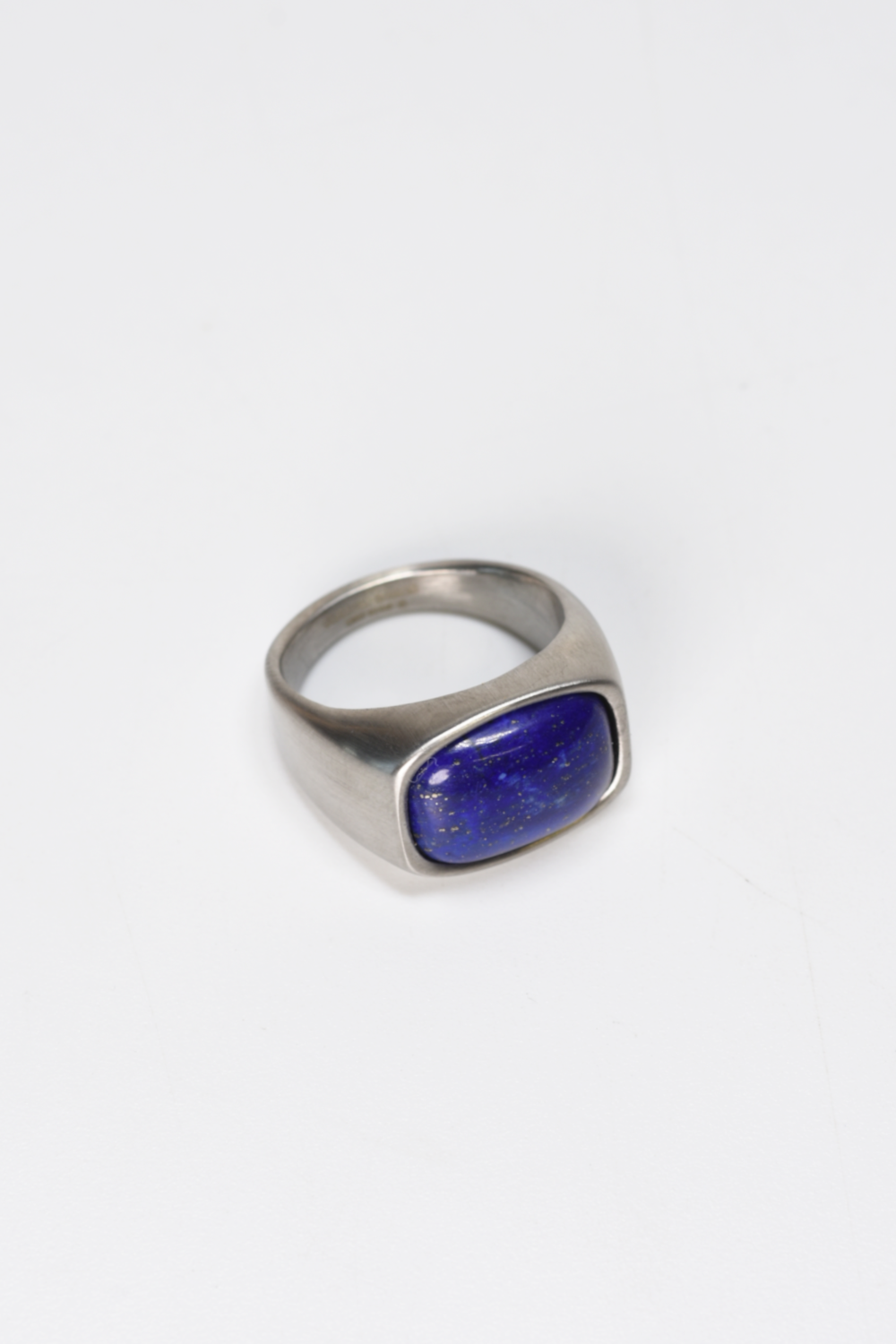 Silver ring with a blue stone on a white background