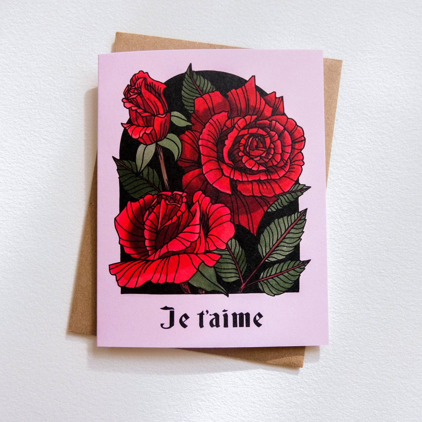 Greeting card with red roses and 'Je t'aime' text on a pink background