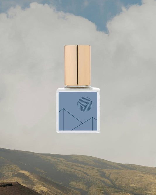 Perfume bottle with a mountain and cloud background