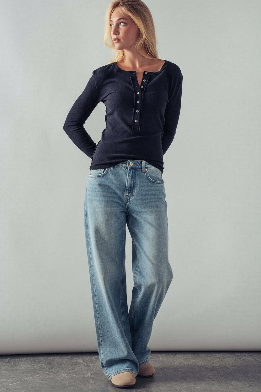 Woman wearing a dark blue top and leopard print pants against a plain background