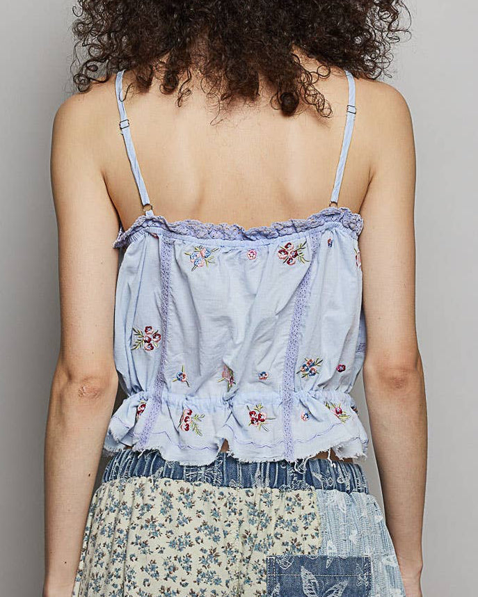 Woman wearing a light blue floral top with a plain background