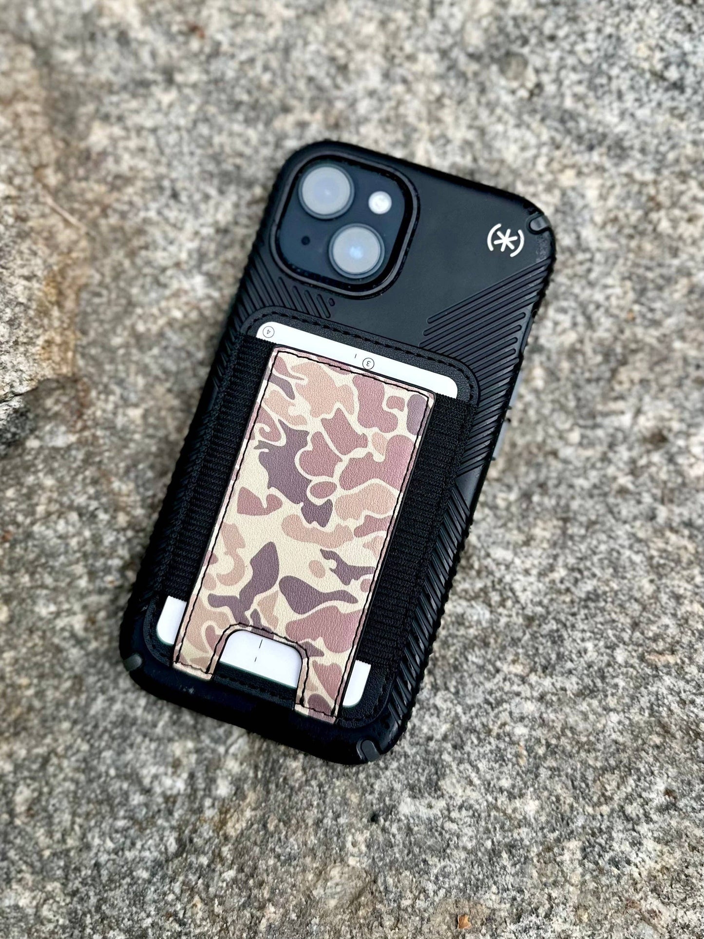 Phone case with camouflage design on a textured surface