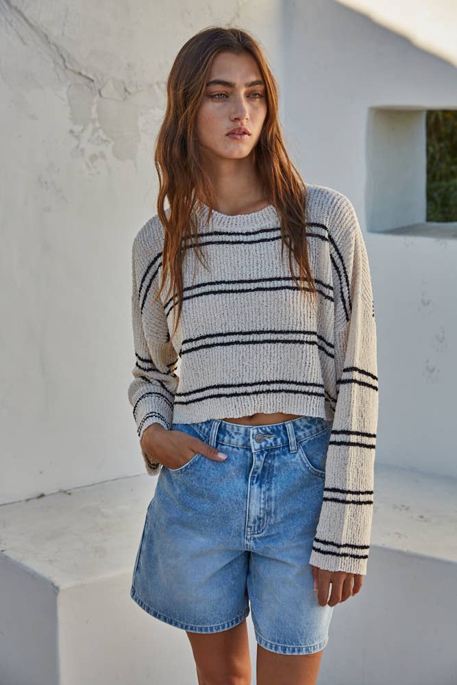 Cropped ribbed crew neck sweater with double-striped pattern, relaxed fit, and dropped shoulders in soft polyester fabric.