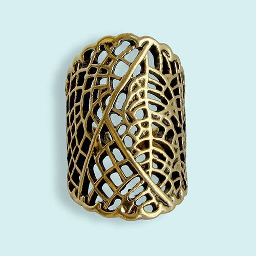 Gold leaf-shaped ring on a light blue background