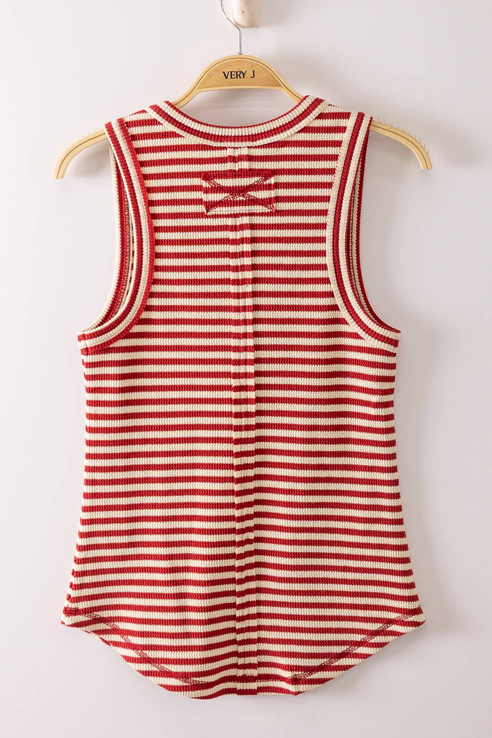 Red and white striped tank top on a hanger against a white background